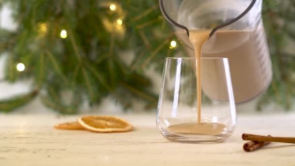 Παραδοσιακό αλκοολούχο κοκτέιλ eggnog χειμώνα ρίχνει από μια κανάτα σε ένα ποτήρι. — Αρχείο Βίντεο
