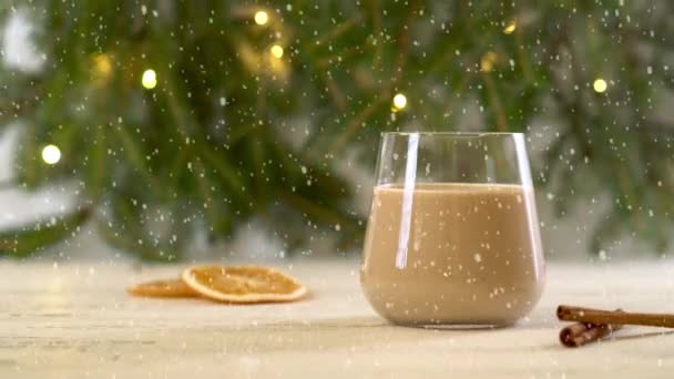 Schnee fällt auf Eggnog - Weihnachtsgetränk mit Milch, Rum, Zimt und Muskatnuss. — Stockvideo