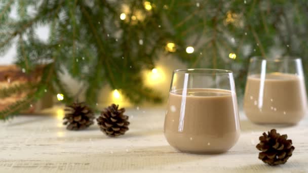 Traditionele kerstdrank Eggnog met ei, melk, suiker. Sneeuw valt.. — Stockvideo