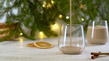 Geleneksel kış alkollü eggnog kokteyli bardağa dökülüyor. Yavaş çekim.