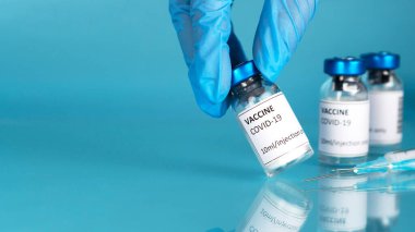 Coronavirus aşısı geçmişi. Doktorların eldivenli elleri aşıyı alıyor. Aşı şişesiyle Covid-19 aşısı. Corona aşılama tedavisi için şırınga enjeksiyon aracı.