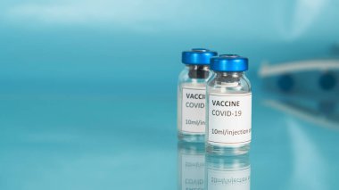 Coronavirus sars-cov-2 aşı şişesi. Uçağın mavi arka plandaki kanadı. Aşı şişeleriyle Covid-19 aşısı. Salgına karşı aşı. Boşluğu kopyala.