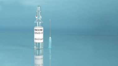 Coronavirus sars-cov-2 aşısı. Korona bağışıklık tedavisi için aşı ampulü ve şırınga enjeksiyonu ile Covid-19 aşısı. Salgına karşı aşı. Mavi arka plan. Boşluğu kopyala.