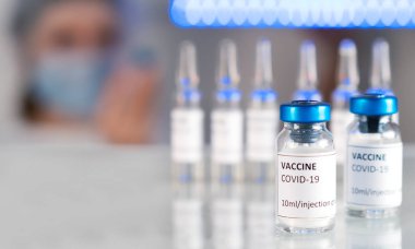 Covid-19 konsepti. Koronavirüsün laboratuvar analizi, enfeksiyon kimyasal araştırması. Coronavirus covid-19 ve salgına karşı aşı. Covid-19 aşısı için aşı tüpleri.
