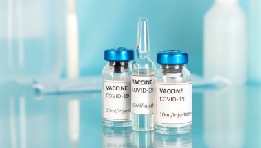 Aşı tüpleri ve ampullerle Covid-19 aşısı. Coronavirus covid-19 aşısı ve pandemik konsept. Covid virüsünü durdur. Karantina sona erdi. Yüz maskesini çıkar. Laboratuvar arkaplanı.