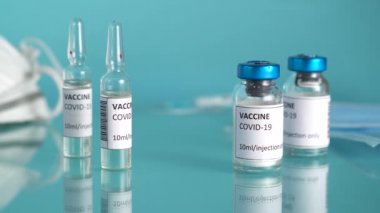 Covid-19 aşı konsepti. Eldivenli doktor Coronavirus aşısı şişesini ve şırıngayı laboratuardaki masaya koydu..