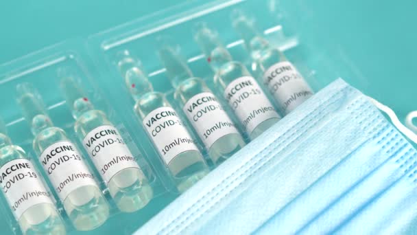 Coronavirus sars-cov-2 Covid-19 aşı tüpleri. Salgının sona ermesi konsepti. Aşı virüsle savaşıyor. Mavi tıbbi geçmiş. Yakınlaştır. — Stok video