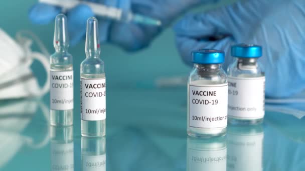 Vacunación contra el Coronavirus con frascos de vacuna y ampollas. Los médicos sostienen la jeringa y el vial de vacuna para curar el coronavirus. — Vídeo de stock