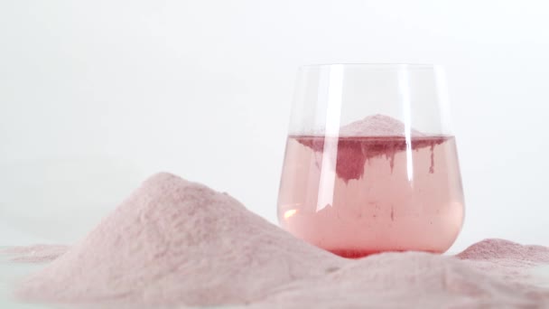 Natural strawberry collagen protein powder for skin regeneration. Trendy food additives. Collagen powder in glass of water, healthy and anti age concept. Horizontal orientation. — Stock Video