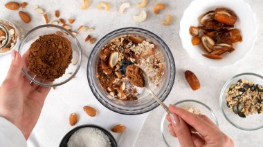 Adım adım enerji toplarını pişiriyorum. Pişirme enerjisi toplarının beşinci aşaması. Kakao tozu ve diğer malzemeleri miksere ya da yiyecek işlemcisine ekliyorum. Sağlıklı çiğ tatlı, vejetaryen şekerler. Üst görünüm.