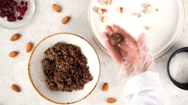 Adım adım enerji toplarını pişiriyorum. Pişirmemenin 8. aşaması enerji topları. Ceviz, hurma, kakao tozu, hindistan cevizi taneleri, yulaf ve kuru kızılcık karışımından yuvarlak toplar yapıyorum. Sağlıklı beslenme.