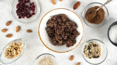 Adım adım enerji toplarını pişiriyorum. Pişirme enerjisi toplarının yedinci aşaması. Fındık, hurma, kakao tozu, hindistan cevizi taneleri, yulaf ve kuru kızılcık karışımı hazır. Tatlı, besleyici tatlı..