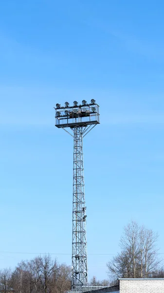 Ishallens ljus mot blå dagtid himmel bakgrund. Ljus LED stadion ljus på en hög stång på en idrottsplan, fotboll — Stockfoto