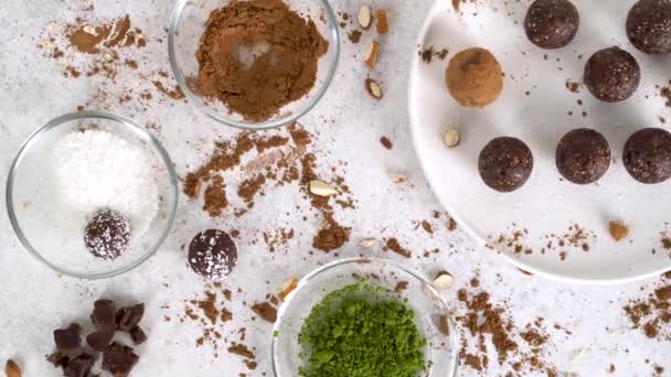 Boules énergétiques recouvertes de matcha, noix de coco et cacao en poudre. Rotation de la came, zoom avant. — Video