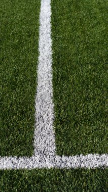 Yapay yeşil çimen futbol sahasında beyaz çizgi işareti. Futbol, futbol sahası. Futbol stadyumundaki çizgiler. Spor geçmişi.