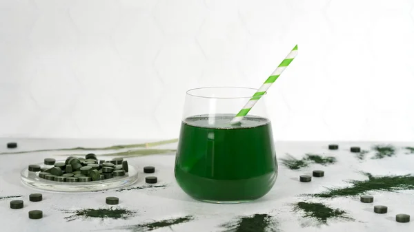 Etrafa saçılmış yeşil spirulina alg tozu ve spirulina içeceği ve spirulina klorella hapları. Süper yiyecek, detoks içeceği. Sağlıklı bakım konsepti. Yan görüş. Yatay yönelim. — Stok fotoğraf