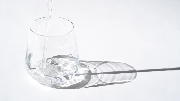 El agua cristalina se vierte de una jarra en un vaso. Vaso de agua dulce pura. — Vídeos de Stock