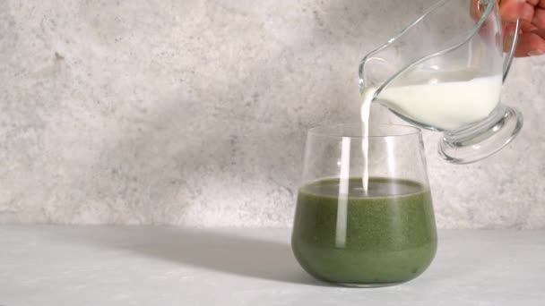 Detoxikační drink. Superfood. Mléko se nalévá do sklenice spirulinového koktejlu. — Stock video