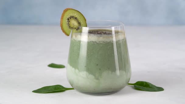 Detox drinken. Supervoedsel. Kiwi rolt langs het glas Spirulina smoothie. Langzaam. — Stockvideo