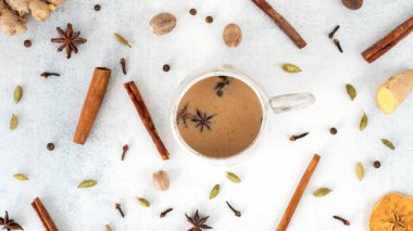 Geleneksel Hint Masala çayı seramik bardakta: tarçın, zencefil, hindistan cevizi, kakule, anason, bal, karanfil. Sütlü acılı siyah çay. Üst görünüm.