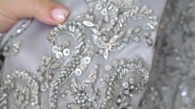 Terzi ya da terzi dantel kumaşı boncuklarla dikiyor. Moda koleksiyonu.