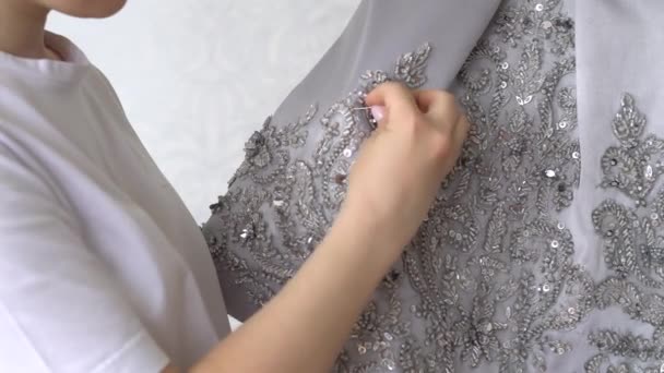 La couturière ou le tailleur coud le tissu de dentelle avec des perles. Collection de mode. — Video