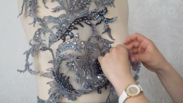 Młody projektant mody przyszywa koronkową tkaninę do manekina, przygotowując kolekcję. — Wideo stockowe