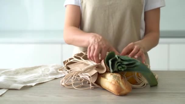 As mãos de mulheres tiram verduras do saco de malha de compras. Resíduos zero. — Vídeo de Stock