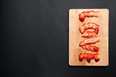 Kesme tahtası üzerinde çilek ile aşk yazma