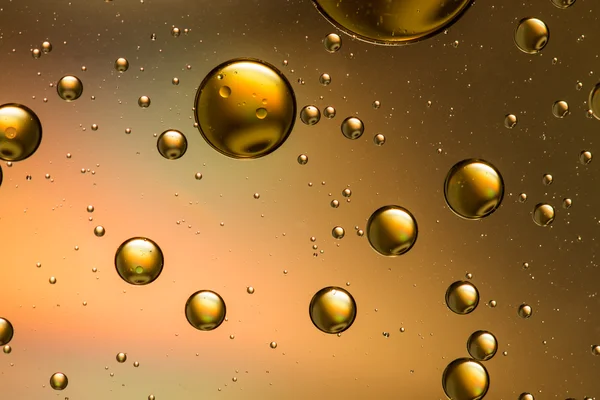 Oil and water abstract in gold, with a rainbow effect — Stock Photo, Image