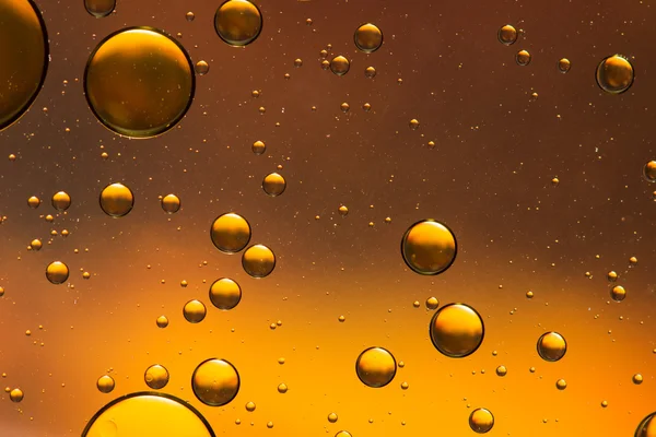 Oil and water abstract in orange and gold — Stock Photo, Image