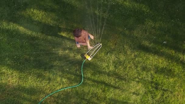 Kind spielt in Sprinkleranlage — Stockvideo