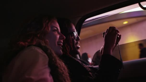 Parejas jóvenes cabalgando en taxi — Vídeos de Stock