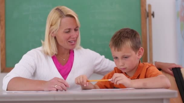 Professor na escola ajuda aluno — Vídeo de Stock