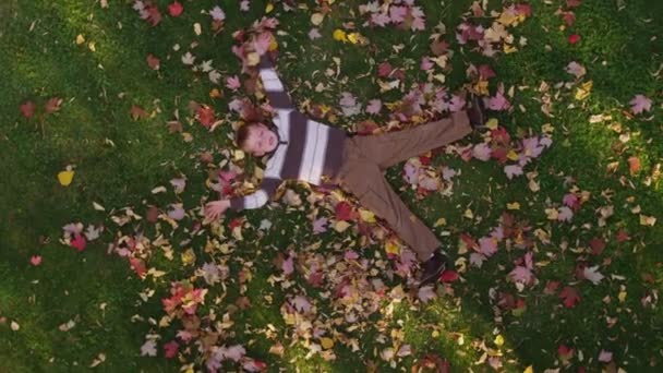 Chlapec hraje s podzimními listy — Stock video