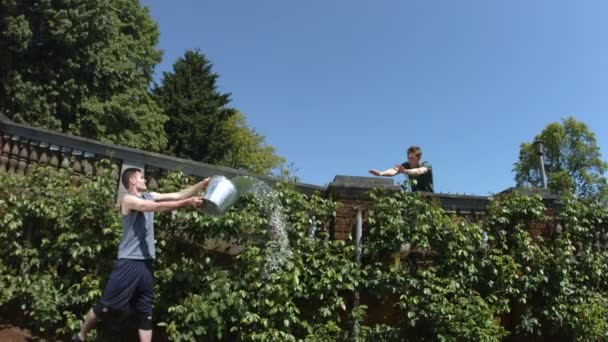 Löpare hoppar genom hink med vatten — Stockvideo