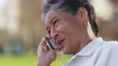 Adam cep telefonuyla konuşuyor.