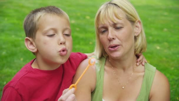 Mãe e filho soprando bolhas — Vídeo de Stock