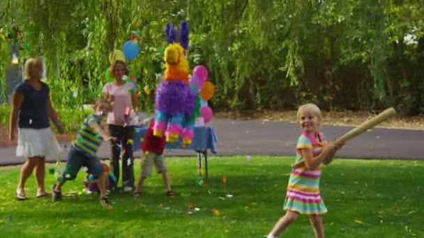 Flickan som slår en pinata — Stockvideo