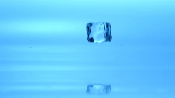 Ice cube falling in water — Stockvideo