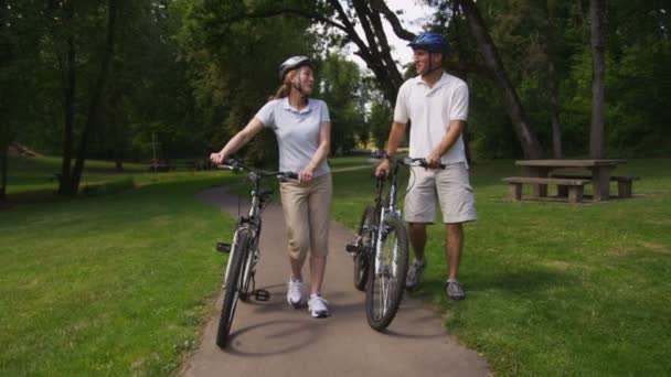 Pareja caminando con bicicletas — Vídeo de stock