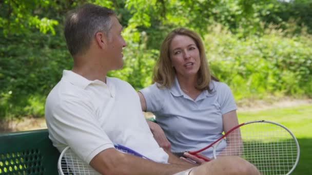 Pareja tomar un descanso de jugar al tenis — Vídeo de stock