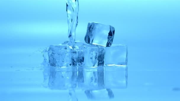 Verter agua sobre cubos de hielo — Vídeo de stock