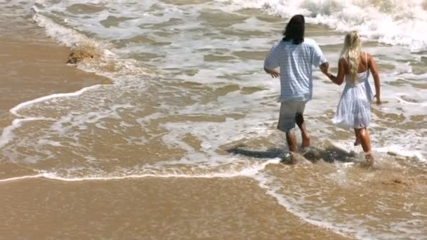 Couple running in ocean surf — Stock Video