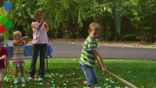 Junge schlägt auf Pinata ein — Stockvideo