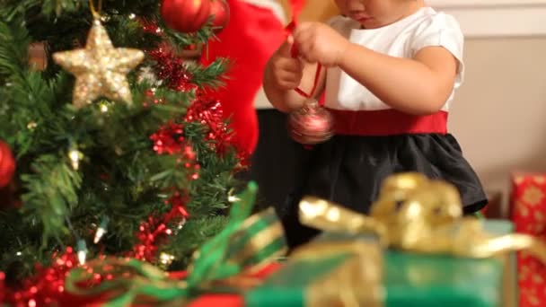 Chica poniendo ornamento en el árbol de Navidad — Vídeos de Stock