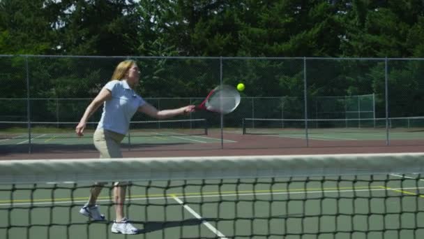 Mujer golpea pelota de tenis — Vídeo de stock