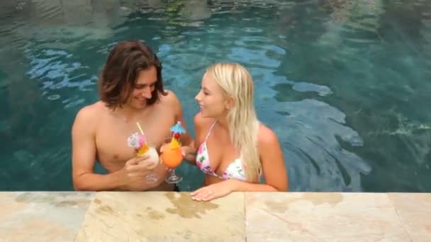 Casal com coquetéis na piscina — Vídeo de Stock
