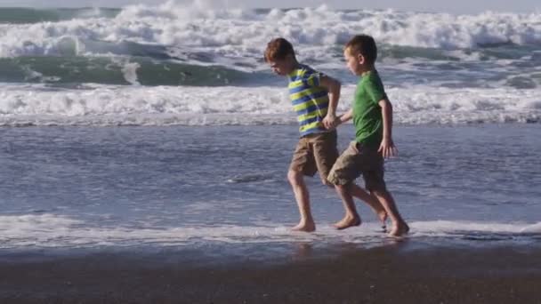 Chicos corriendo en la playa — Vídeo de stock