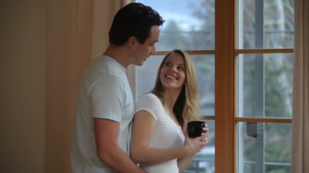 Paar kijkt uit raam — Stockvideo